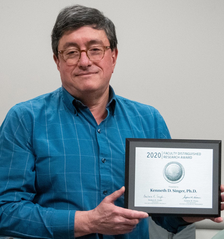 Photo of Kenneth Singer holding an award plaque