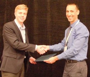Kevin Pachuta shakes hands with award presenter