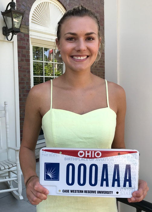 Photo of Maggie Tyma holding a CWRU-branded license plate