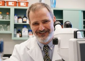 Photo of Martin Basch in front of a microscope