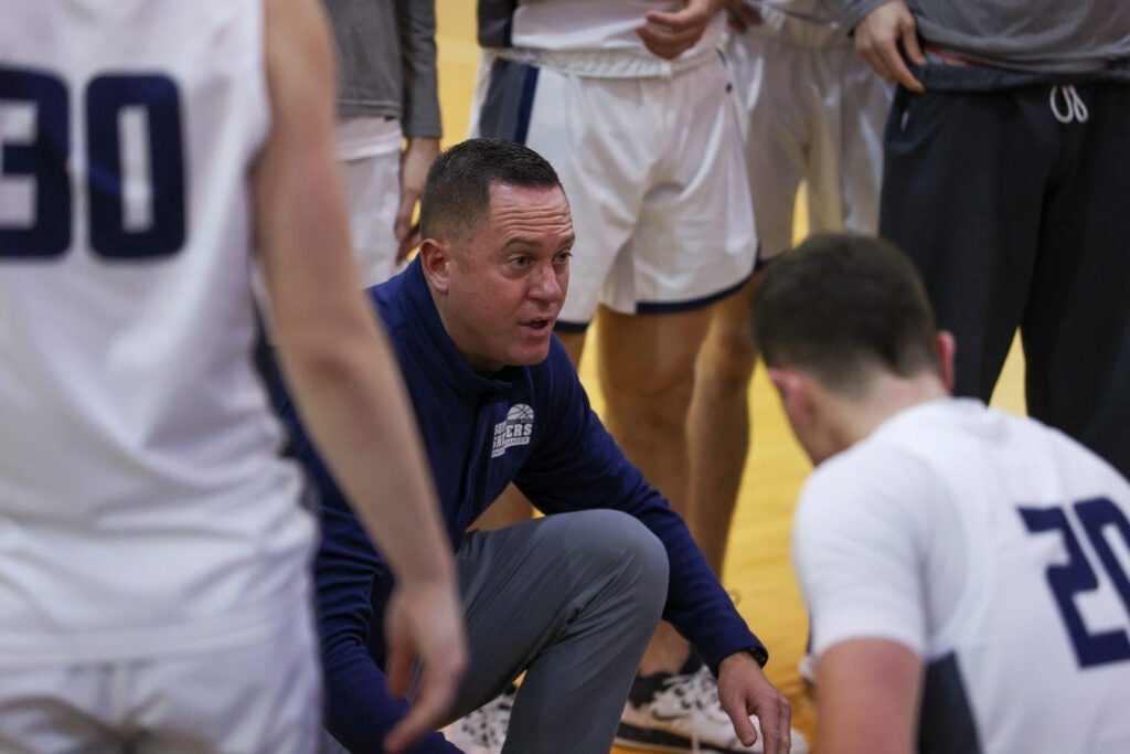 Photo of the men's basketball talking to the players on the sideline