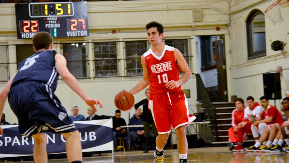 Photo of a men's basketball player wearing a Western Reserve University jersey dribbling the ball during a throwback game