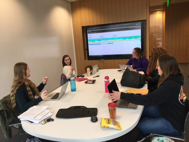 Photo of five students sitting around a conference table