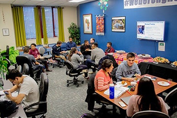 Students gathered in a room participating in an OMA Kickback