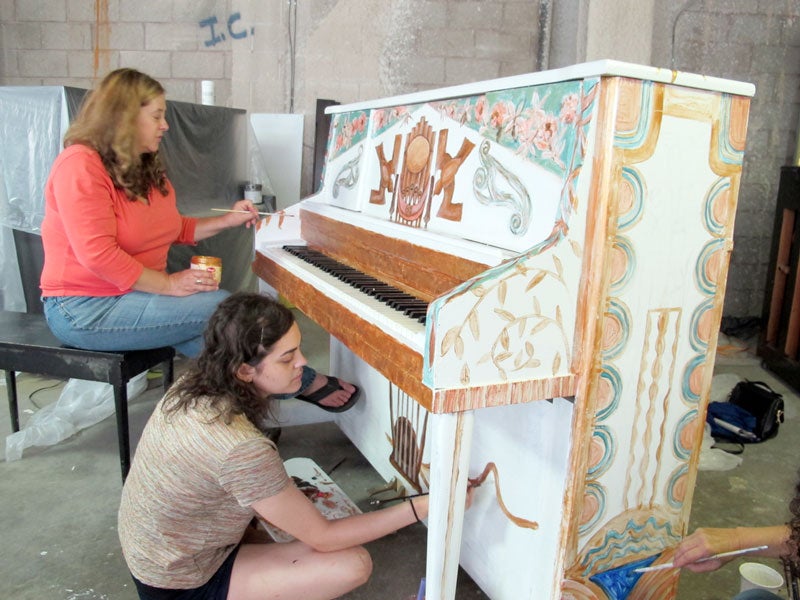 Painters work on the Cleveland Orchestra's piano.