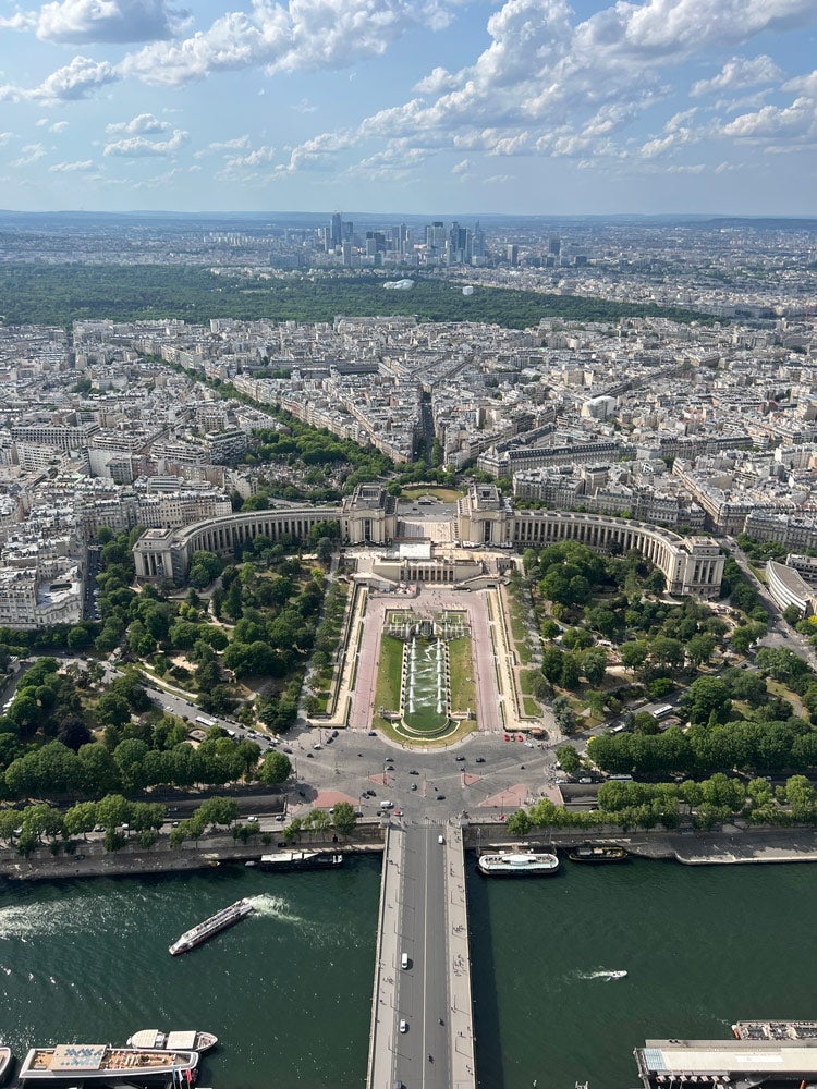 Photo taken from the Eiffel Tower showing the buildings and greenery of Paris