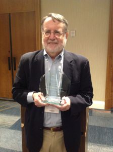 Photo of Paul Giannelli holding lifetime achievement award