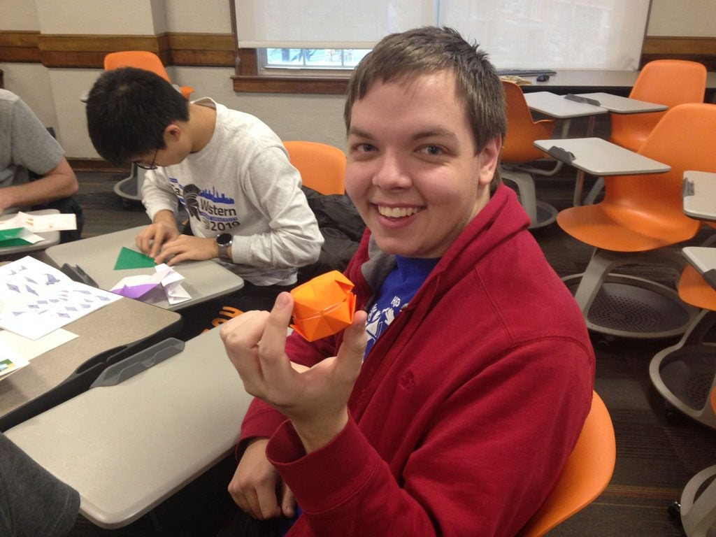 Paul Schroeder holds up origami piece 