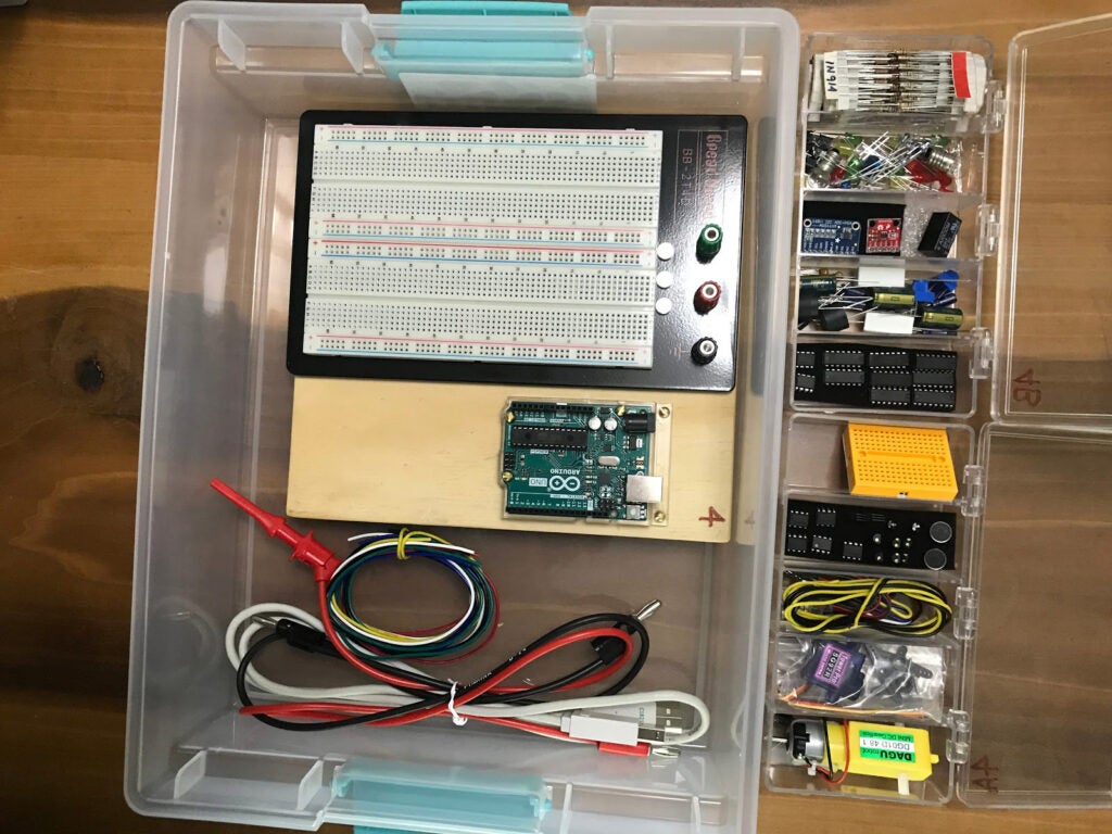 Photo showing the contents of an Arduino-based kit in plastic containers full of electronic materials for students