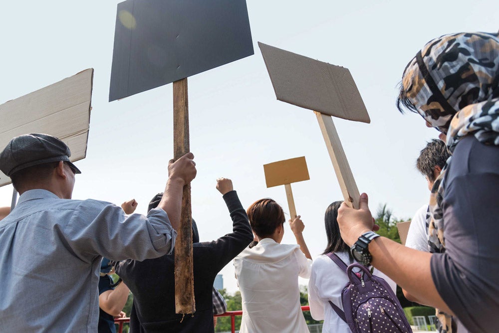 Photo taken behind protesters holding signs up