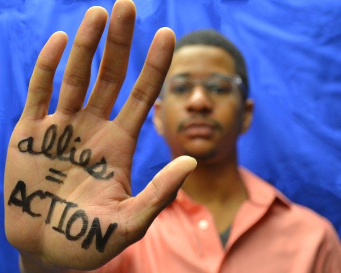 Photo of Richard McGuire with his "allies = actions" written on his outstretched hand