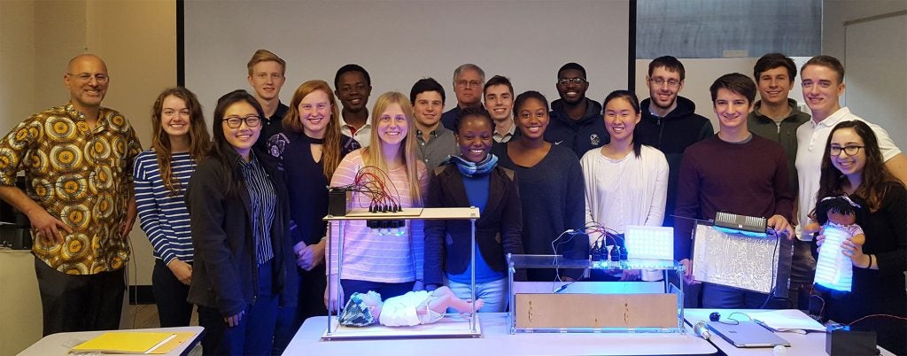 Group photo of SAGES class students with Uche Anene-Nzelu and Dan Lacks with student phototherapy device prototypes