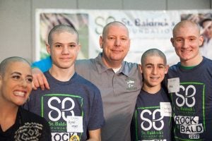 Photo of five people with shaved heads at a previous Shave It Off event