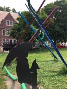 Photo of Snow Fence art installation on Case Western Reserve University with focus on silhouette of woman with umbrella and dog