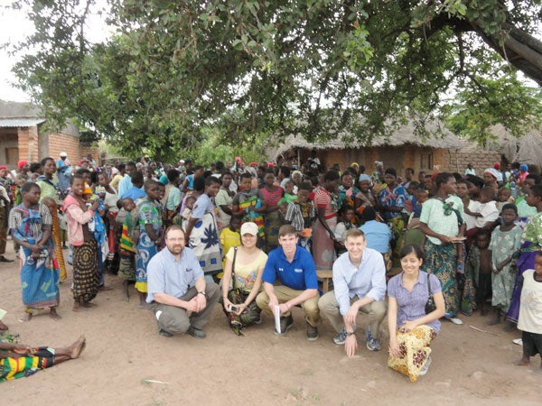 CWRU students and professor stand with residents in Malawi