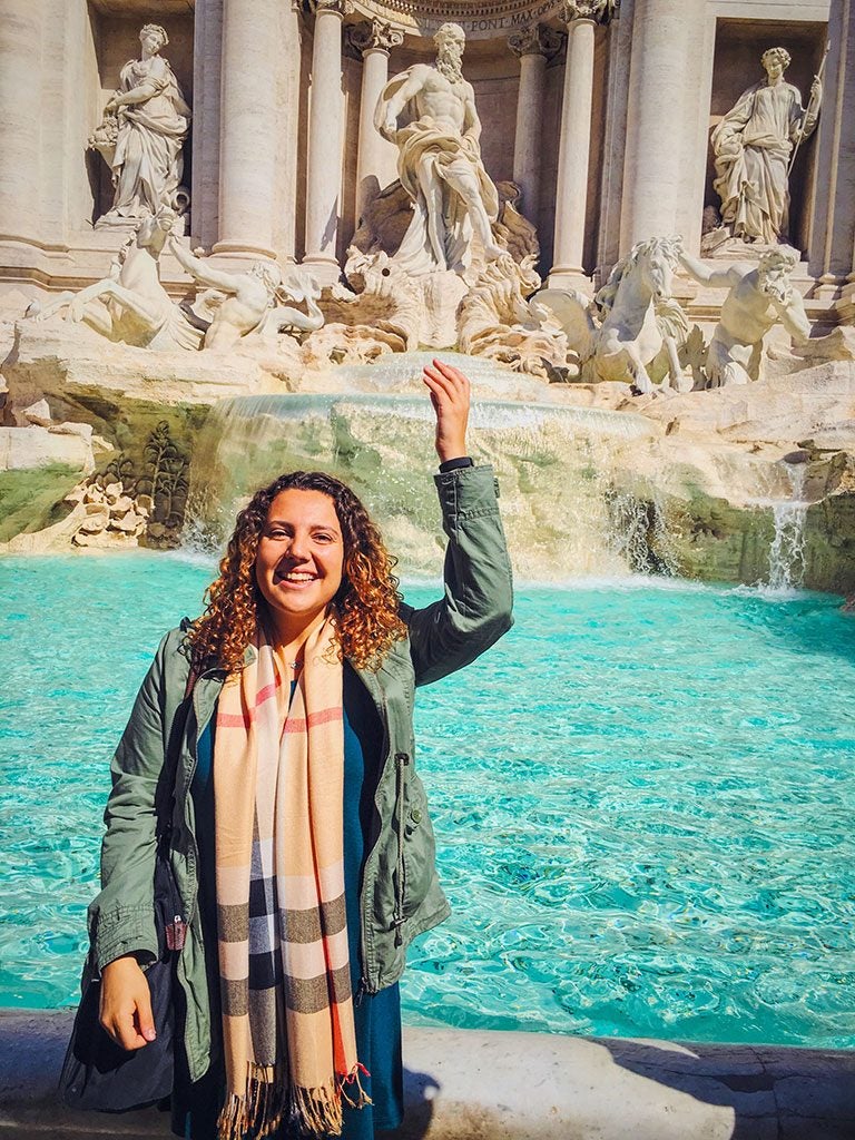 Student throwing coin into Trevi Fountain in Rome