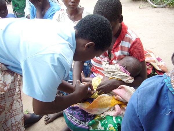 Malawi health care worker gives infant vaccination