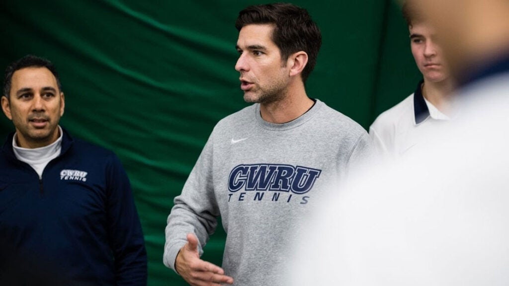 Photo of Todd Wojtkowski talking with men's tennis players