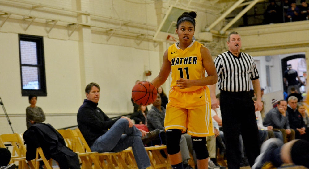 Photo of a women's basketball player wearing a Mather College jersey dribbling the ball during a throwback game