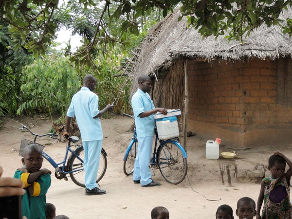 Health care workers in Malawi bike to villages to give vaccinations