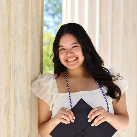 Elena Cangahuala holding her mortar board