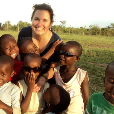 Lisa Alverto outside in Africa with young smiling children