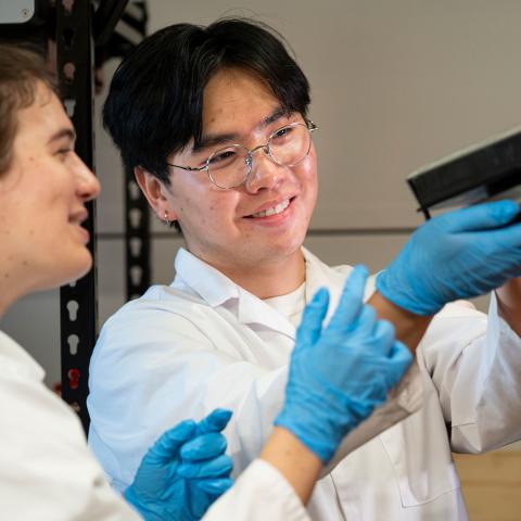 Photo of two CLEANR employees looking at a 3D printer part