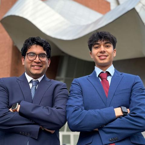 Dev Gupta and Sunveer Chugh pose for a photo in front of the Peter B. Lewis Building