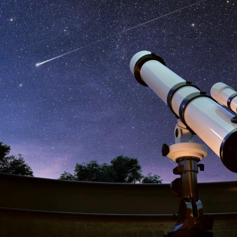 Telescope points to starry night sky