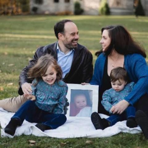 Tony and Laura Corsi posing with their two children, as well as a picture of their son Luca who passed away