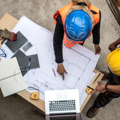 Two architects examine a blueprint.