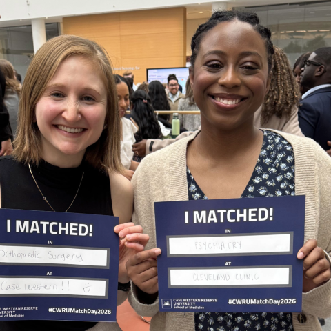 two students smiling together with their match day papers