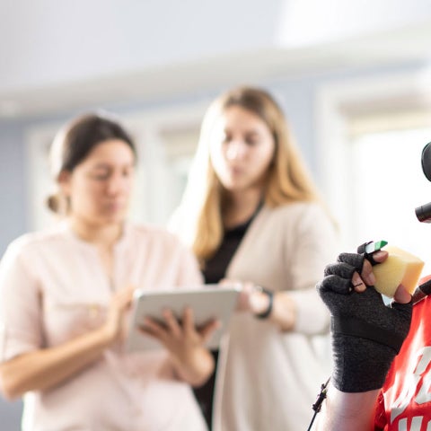Photo of a man with quadriplegia holding an item with the help of a brain-computer interface