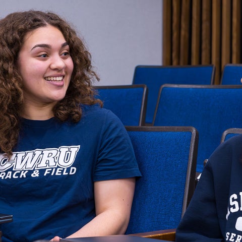Photo of two CWRU students speaking to each other in a classroom