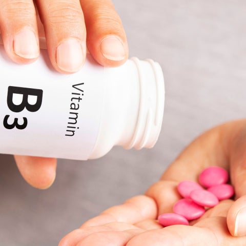 Close up of hands holding Vitamin B3 pills