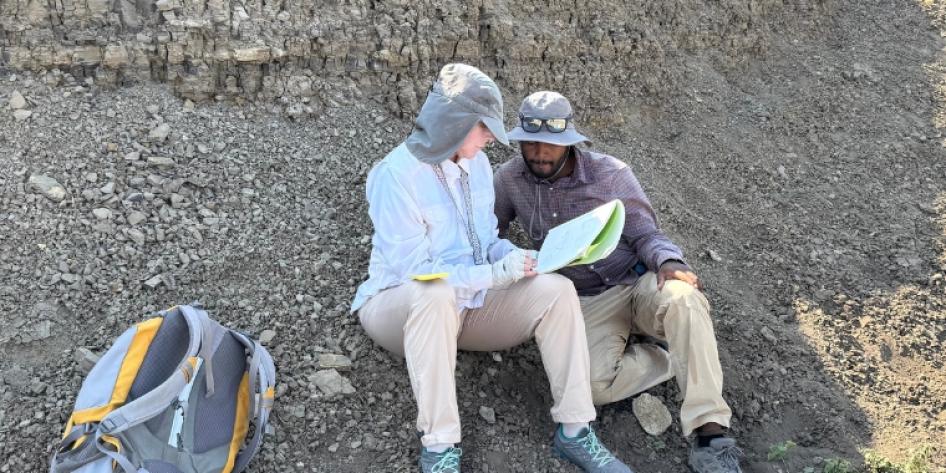 Takele Mihretie and Beverly Saylor looking at a notebook
