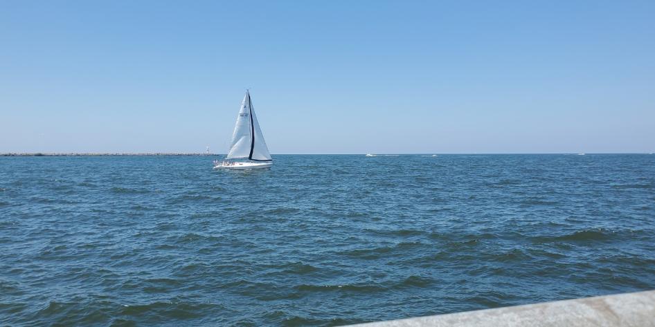 A sailboat glides peacefully across the waters of Lake Erie on a clear day. Photo by Juan Jeffrey.