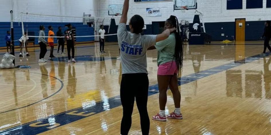 Two teenagers standing on volleyball court
