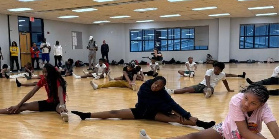 Group of kids stretching on wooden floor