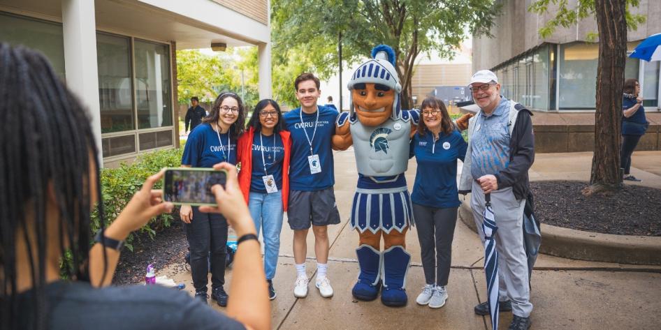 Spartie poses with a group of students, President Eric W. Kaler and his wife, Karen, during a CWRU first-year move-in. 
