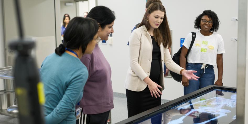 Four people view the Anatomage Table