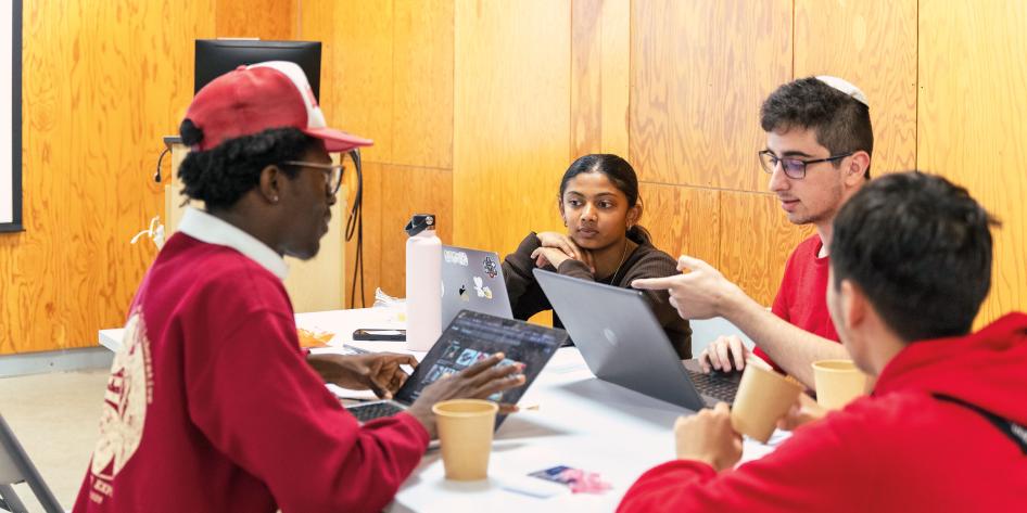 Four students discuss an idea around a table.