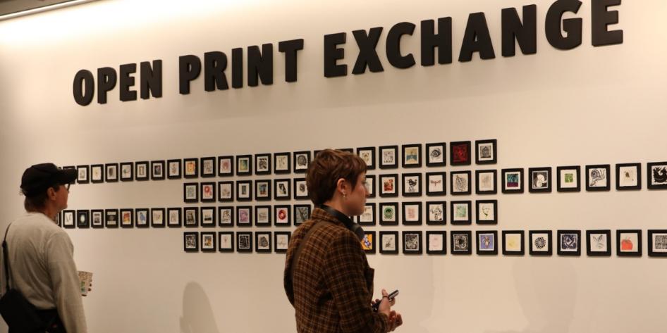 Students view a collection display at the Open Print Exchange exhibit.