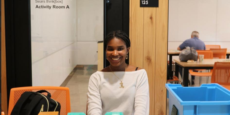 A student poses for a photo at Sears think[box]'s Open Print Exchange exhibit. 
