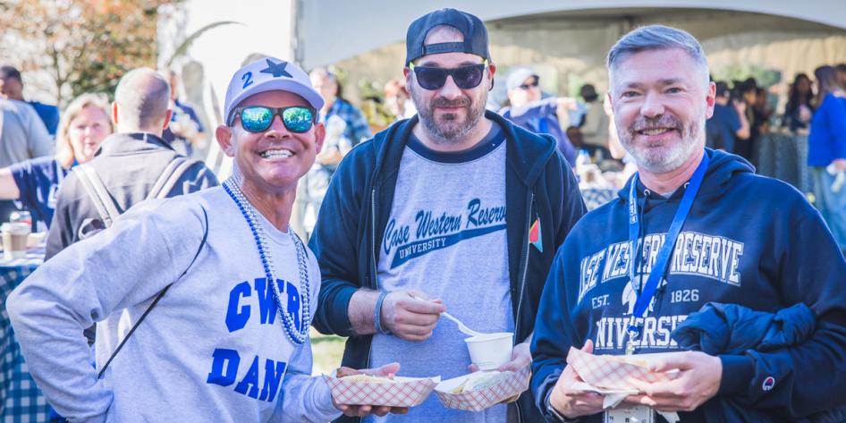 Photo of three CWRU graduates wearing CWRU Blue gear