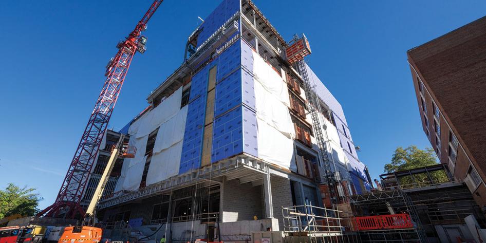 Image of a crane delivering materials to the ISEB on a sunny day