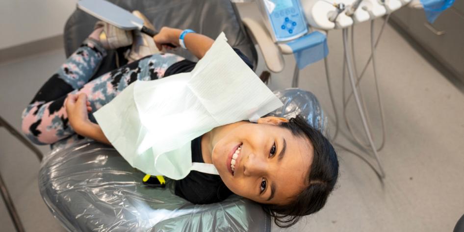Young student smiles from the dental chair.