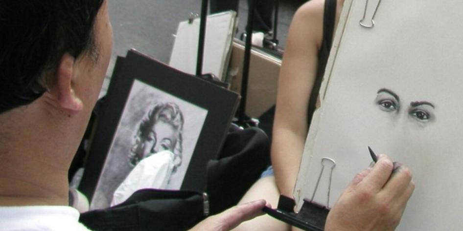 Close up of a New York City street vendor drawing a picture of eyes, captured by Matthias Buck.  