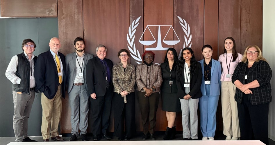 Participants of the “Spring Break in The Hague" program take a group photo in an international courtroom. 