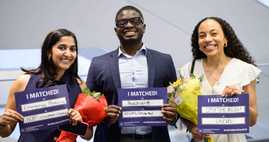 three students posing with their "I matched" papers
